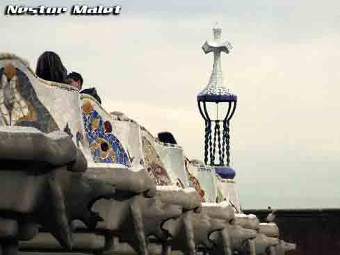 Vista de los bancos de la plaza con la cruz de uno de los pabellones